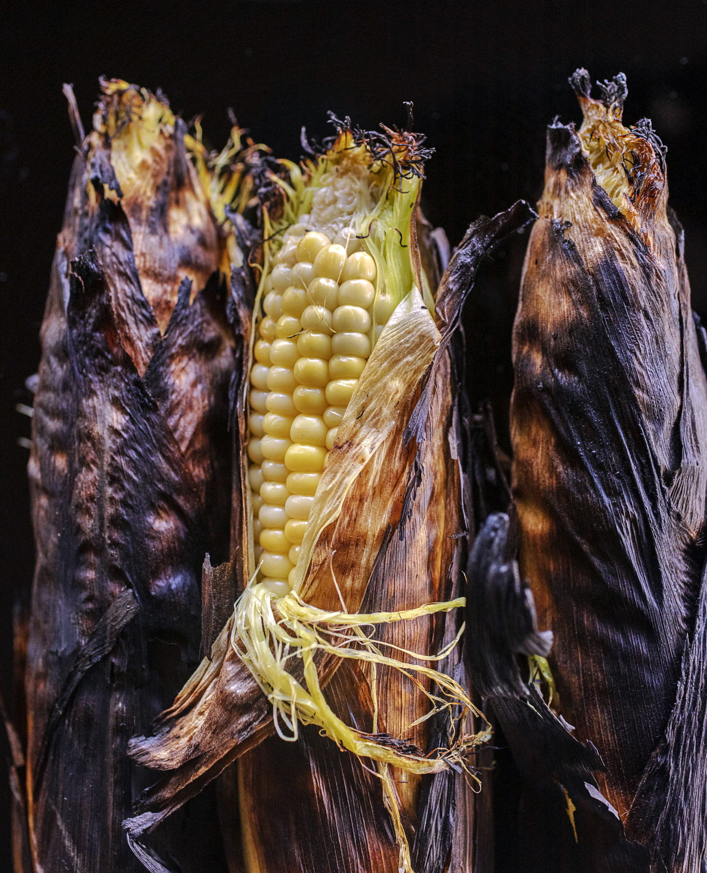 Cookout Corn on the Cob The secret to perfectly grilled campfire corn in their husks by The Unofficial Yellowstone Cookbook author Jackie Alpers.